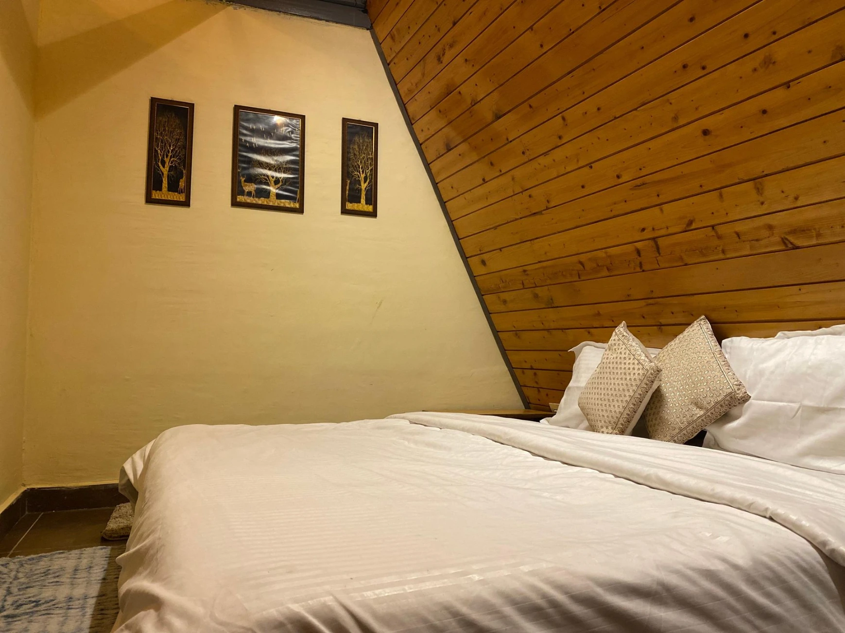 Cozy bedroom inside A-frame cottage in Jibhi
